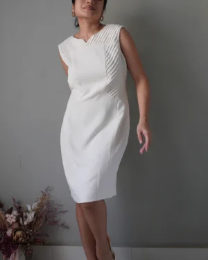 Elevated with pleat accents, edgy white sleeveless dress with zipper at the back