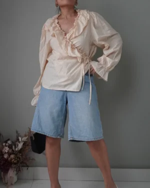 Bisque/has a hint of very light lemonade pink ruffled wrap top with long sleeves
