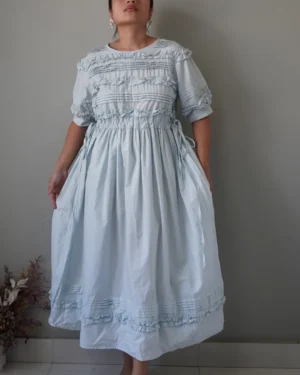 Soft blue dress with ruffle details, puffed sleeves and self tie side ribbons